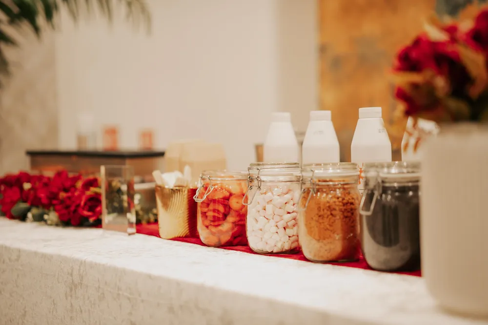 Glass jars holding strawberries, marshmallows and other dessert toppings