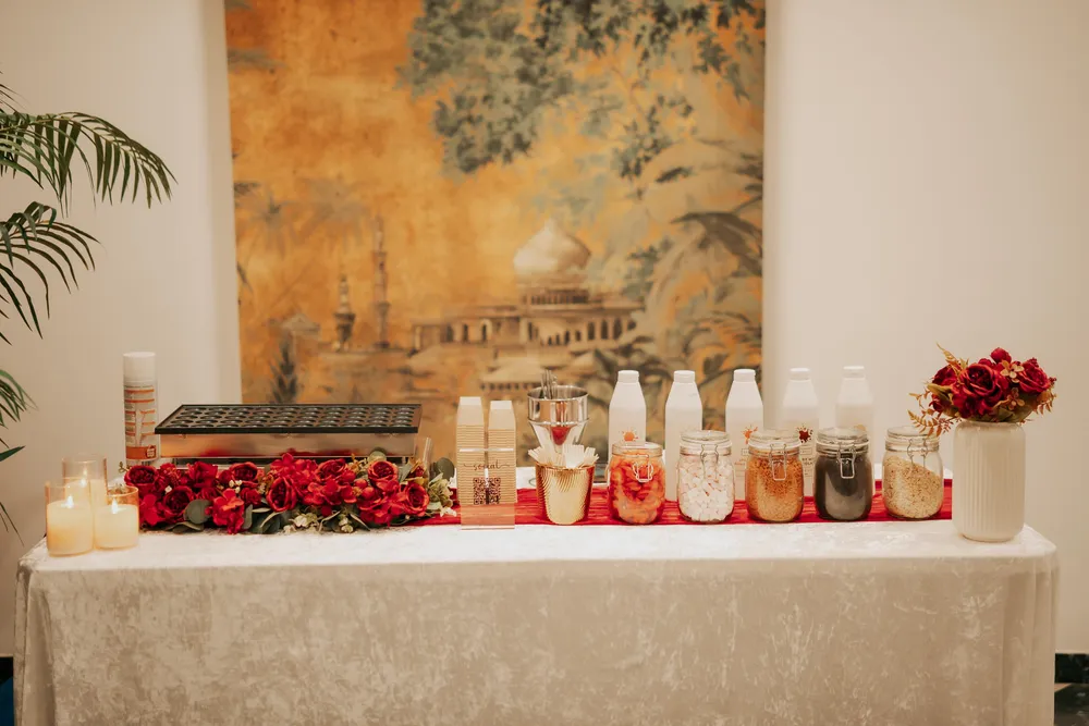 Complete mini pancake station with red flowers, candles and dessert toppings