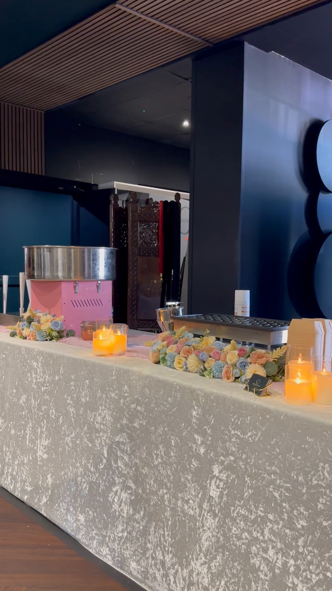 Crescent Events dessert station with candyfloss and mini pancake equipment, flowers and candlelit decorations